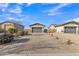 Charming home showcasing a three-car garage and manicured gravel landscaping, enhanced by a beautiful paver driveway at 21036 E Stacey Rd, Queen Creek, AZ 85142