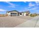 Charming home featuring manicured gravel landscaping, complemented by a beautiful paver driveway and three-car garage at 21036 E Stacey Rd, Queen Creek, AZ 85142