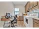 Functional laundry room with a workspace desk, upper and lower cabinets, and modern appliances at 21036 E Stacey Rd, Queen Creek, AZ 85142