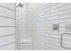 Walk-in shower featuring subway tile, a built-in seat, and a glass door at 21036 E Stacey Rd, Queen Creek, AZ 85142