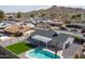 Aerial shot of backyard showcasing pool, artificial lawn, covered patio, and gray gravel at 2212 E Hillery Dr, Phoenix, AZ 85022