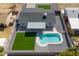 Drone shot showcases the swimming pool, artificial lawn, and the home's gray roof at 2212 E Hillery Dr, Phoenix, AZ 85022