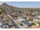 An elevated view features a pool home amidst a well-maintained residential area near majestic mountains at 2212 E Hillery Dr, Phoenix, AZ 85022