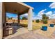 Back patio with brick paving, white support column, outdoor bench, two large blue planters and grassy backyard at 2562 E Oxford Ct, Gilbert, AZ 85295