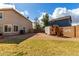 Spacious backyard featuring a playhouse, storage shed, grass area, and block wall fencing at 2562 E Oxford Ct, Gilbert, AZ 85295