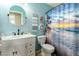 Bathroom featuring a vanity with modern black faucet, round mirror, and a shower with an ocean-themed curtain at 2562 E Oxford Ct, Gilbert, AZ 85295