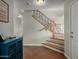 Elegant foyer with wood staircase, iron railings, and tiled floor, complemented by a stylish blue console at 2562 E Oxford Ct, Gilbert, AZ 85295