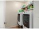 Bright laundry room with front load washer and dryer, overhead shelving, and laminate wood-look flooring at 2562 E Oxford Ct, Gilbert, AZ 85295