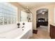 Bright bathroom features a glass block window, a tub, and a separate shower at 2708 E Desert Rose Trl, San Tan Valley, AZ 85143