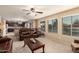 Bright and open living room with leather couches, a ceiling fan, and an eat-in kitchen at 2708 E Desert Rose Trl, San Tan Valley, AZ 85143