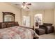 Serene bedroom with a view to the bathroom, neutral tones, ceiling fan, and plush carpet flooring at 2708 E Desert Rose Trl, San Tan Valley, AZ 85143