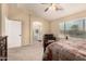 Serene bedroom with a view to the bathroom, neutral tones, ceiling fan, and plush carpet flooring at 2708 E Desert Rose Trl, San Tan Valley, AZ 85143