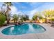 Sparkling backyard swimming pool features a rock waterfall and lush tropical landscaping at 2708 E Desert Rose Trl, San Tan Valley, AZ 85143