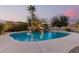 Sparkling pool with a rock waterfall feature, surrounded by lush landscaping and a serene atmosphere at 2708 E Desert Rose Trl, San Tan Valley, AZ 85143