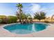 Stunning pool with rock waterfall feature and lush landscaping with a blue sky backdrop at 2708 E Desert Rose Trl, San Tan Valley, AZ 85143