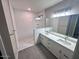 Bathroom featuring double sinks, quartz countertops, and a walk-in shower at 2734 N Trevino Pl, Mesa, AZ 85215