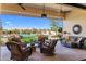 Covered patio featuring stylish wicker furniture overlooking the pool and meticulously kept lawn at 30416 N 64Th Street --, Cave Creek, AZ 85331