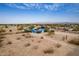 A high aerial view of the property with a blue house and a scenic mountain backdrop at 30446 W Portland St, Buckeye, AZ 85396