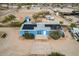 Aerial view of a charming blue house with a large driveway and a small shed in the back at 30446 W Portland St, Buckeye, AZ 85396