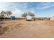 A large backyard with a small shed, camper, trees and dry, dirt yard at 30446 W Portland St, Buckeye, AZ 85396