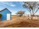 A large backyard with a small shed, camper, trees and clear blue skies at 30446 W Portland St, Buckeye, AZ 85396