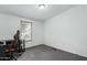 This bedroom has neutral walls and gray carpeting and a rolling gaming chair at 30446 W Portland St, Buckeye, AZ 85396