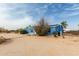 Exterior view of a blue single story home with solar panels, landscaping, concrete drive and a blue sky at 30446 W Portland St, Buckeye, AZ 85396