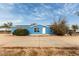 Charming single story home with solar panels and a concrete drive, painted a bright blue and ready to welcome you home at 30446 W Portland St, Buckeye, AZ 85396