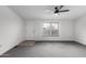 Bright living room with plush carpet, ceiling fan, and a view of the front door with the outside at 30446 W Portland St, Buckeye, AZ 85396