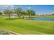 Lush green golf course featuring a serene pond with mature trees and a fountain at 3061 S Elderwood --, Mesa, AZ 85212