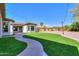 A large backyard with artificial grass, a walking path, and a covered patio at 3527 E Indigo Cir, Mesa, AZ 85213