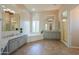 Bright bathroom with tile floors, soaker tub, separate shower, and dual sink vanity at 3527 E Indigo Cir, Mesa, AZ 85213