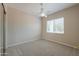 Neutral bedroom features a ceiling fan and a bright window with blinds at 3527 E Indigo Cir, Mesa, AZ 85213