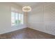 Bright dining room with wood-look tile floors, custom wall trim, and modern chandelier fixture at 3527 E Indigo Cir, Mesa, AZ 85213