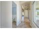 Inviting hallway featuring tile flooring and a convenient powder room with blue wallpaper accent at 3527 E Indigo Cir, Mesa, AZ 85213