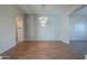 Bright living room with wood floors, modern chandelier, and view of the hallway and doorways at 3527 E Indigo Cir, Mesa, AZ 85213