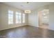 Bright living room with wood floors, modern chandelier, and large windows with plantation shutters at 3527 E Indigo Cir, Mesa, AZ 85213