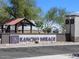 Welcoming entrance to Rancho Mirage featuring prominent signage, desert landscaping, and a covered gazebo at 36972 W Santa Maria St, Maricopa, AZ 85138