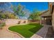 Spacious backyard featuring lush artificial grass, mature trees and bushes, and a paved patio area at 3763 S Laurel Way, Chandler, AZ 85286