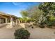 View of backyard with desert landscaping, covered patio and mature trees at 4441 E Via Dona Rd, Cave Creek, AZ 85331