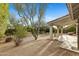 View of backyard with desert landscaping, covered patio and mature trees at 4441 E Via Dona Rd, Cave Creek, AZ 85331