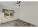 Empty bedroom featuring wood-look floors, ceiling fan and a window showcasing the backyard at 4441 E Via Dona Rd, Cave Creek, AZ 85331