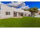 Exterior shot showcasing the expansive backyard, lush green lawn, and covered patio of this lovely home at 5345 E Mclellan Rd # 107, Mesa, AZ 85205