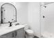 Bathroom featuring a white shower, toilet, vanity, and decorative mirror at 6348 W Hill Ln, Glendale, AZ 85310