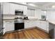 Well-lit kitchen featuring stainless steel appliances, white cabinetry, and laminate countertops at 6348 W Hill Ln, Glendale, AZ 85310