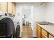 Laundry room featuring a Samsung washer and dryer, sink, and a view into the kitchen at 6348 W Hill Ln, Glendale, AZ 85310