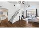 Bright living room with staircase, wood floors, high ceilings, modern furniture, and a view to the backyard at 6348 W Hill Ln, Glendale, AZ 85310