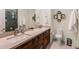 Bathroom with double sinks, wood cabinets, tiled shower, and modern fixtures at 6576 E Whispering Mesquite Trl, Scottsdale, AZ 85266