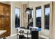 Chic dining area with modern lighting fixture and views to the outdoors from three large picture windows at 6576 E Whispering Mesquite Trl, Scottsdale, AZ 85266