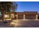 Exterior view showing well-maintained landscaping, desert plants, and a three-car garage at 6576 E Whispering Mesquite Trl, Scottsdale, AZ 85266